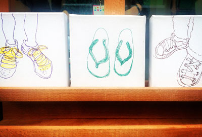 3 small canvases of feet outside the gallery