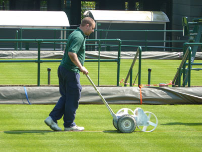 Groundsman painting white lines