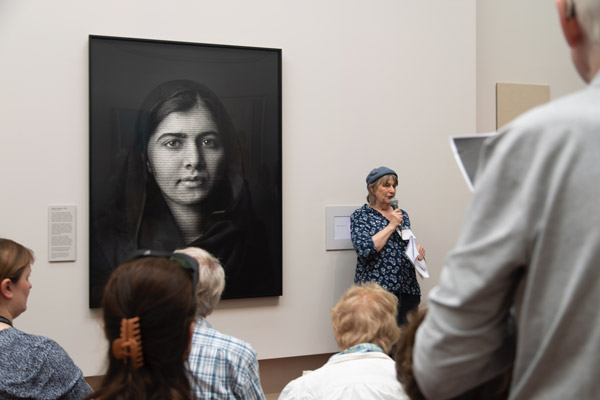 Sally at the National Portrait Gallery, speaking in front of a portrait of Malala. CREDIT Ines Alves/ NPG, London.